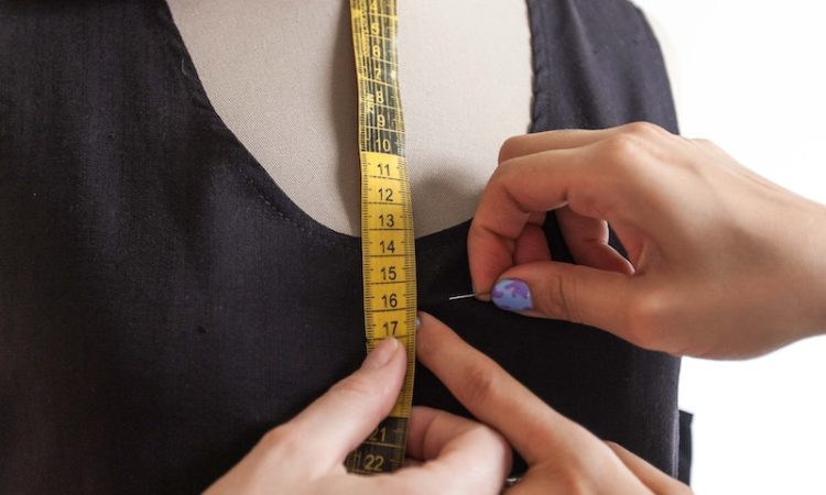 A Person Putting a Pin on a Black Dress